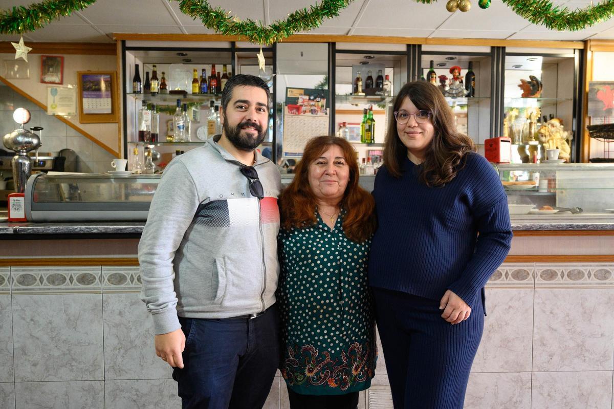 Feli con sus hijos frente a la barra del Bar Lisboa, en el Oliver.