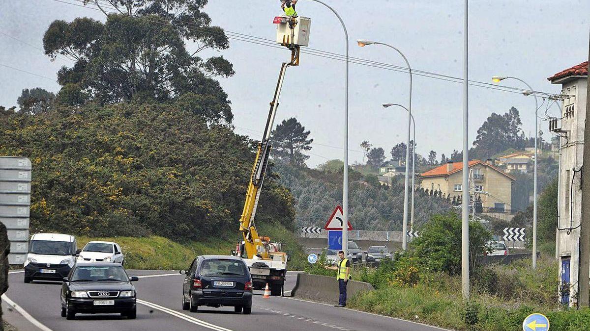 Unos operarios realizan tareas de mantenimiento en unas farolas en Arteixo.