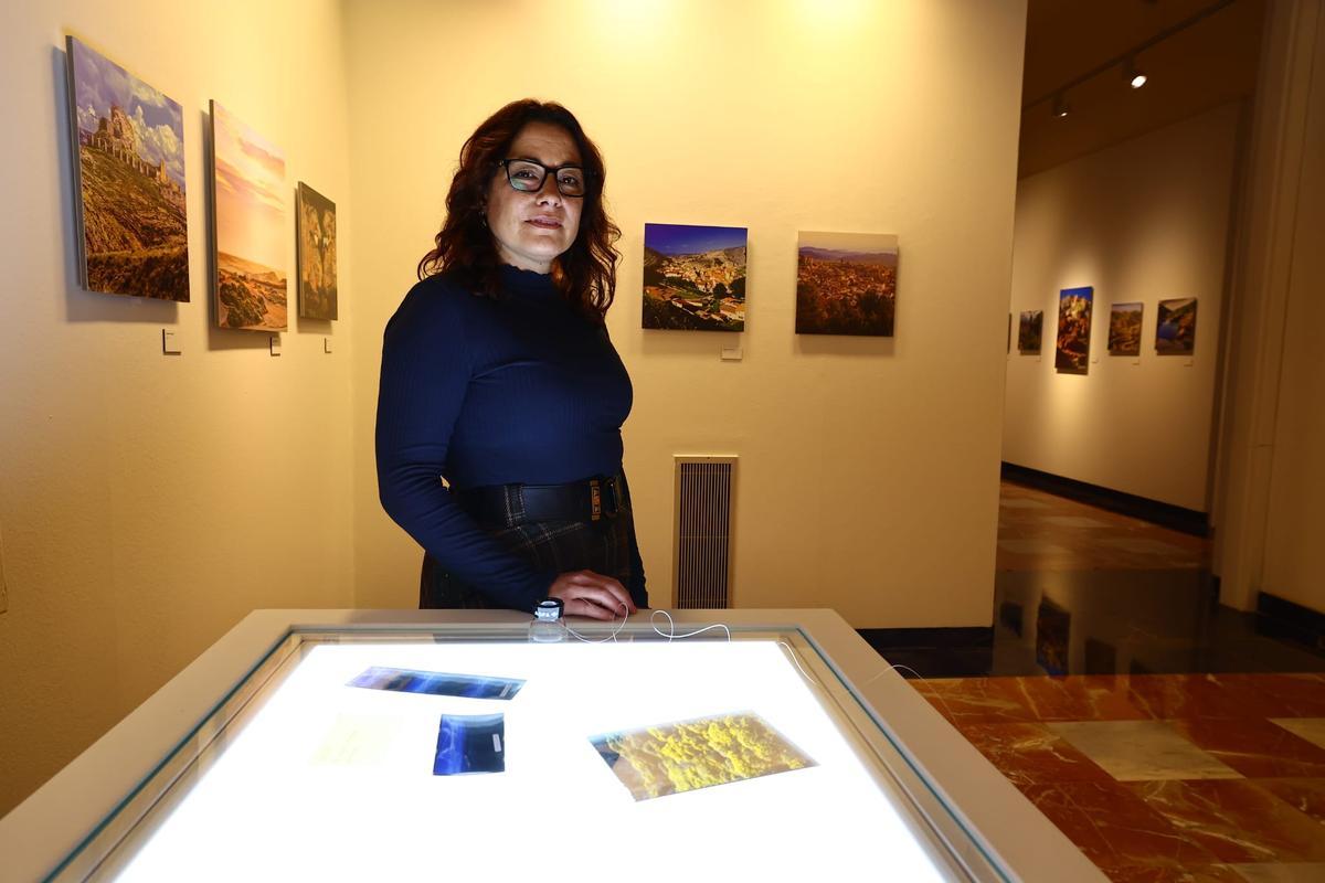 Jara Alvira Franco, comisaria de la exposición e hija de Fernando Lizano, posa junto a una mesa con negativos de su padre
