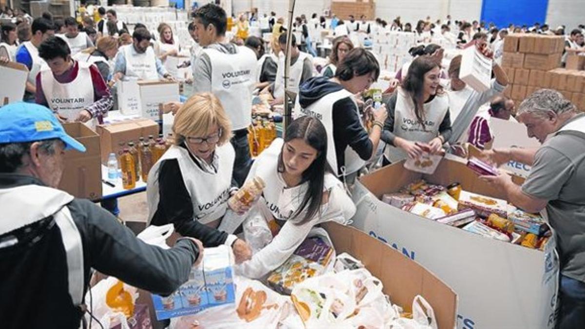 Un equipo de voluntarios clasifica los alimentos recolectados en un almacén de El Prat de Llobregat, ayer.