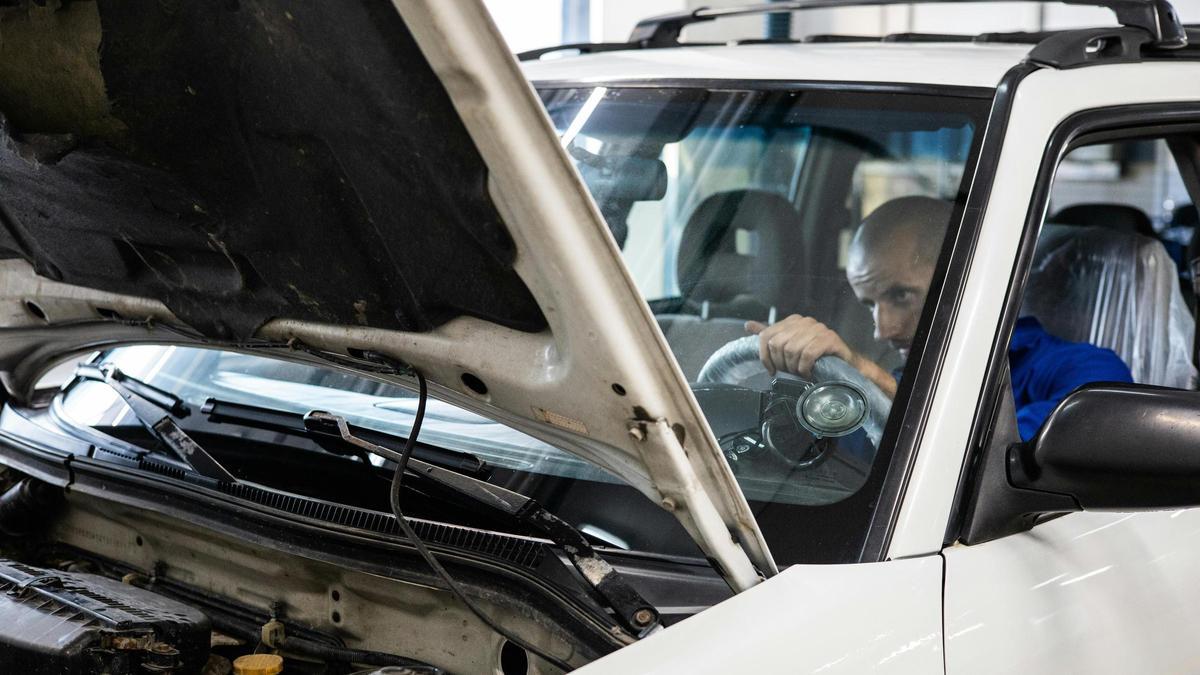 Un trabajador de una ITV inspecciona el interior de un vehículo.