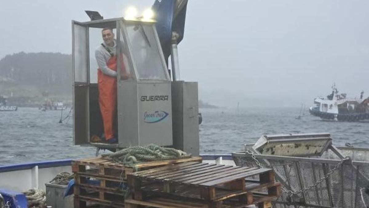 Diego Portela, trabajando en la grúa de su barco auxiliar de acuicultura, en Porto Meloxo.