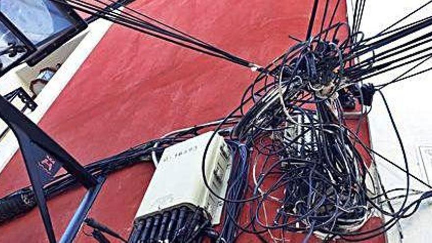 Cables de todo tipo en la fachada de un edificio de Dalt Vila.