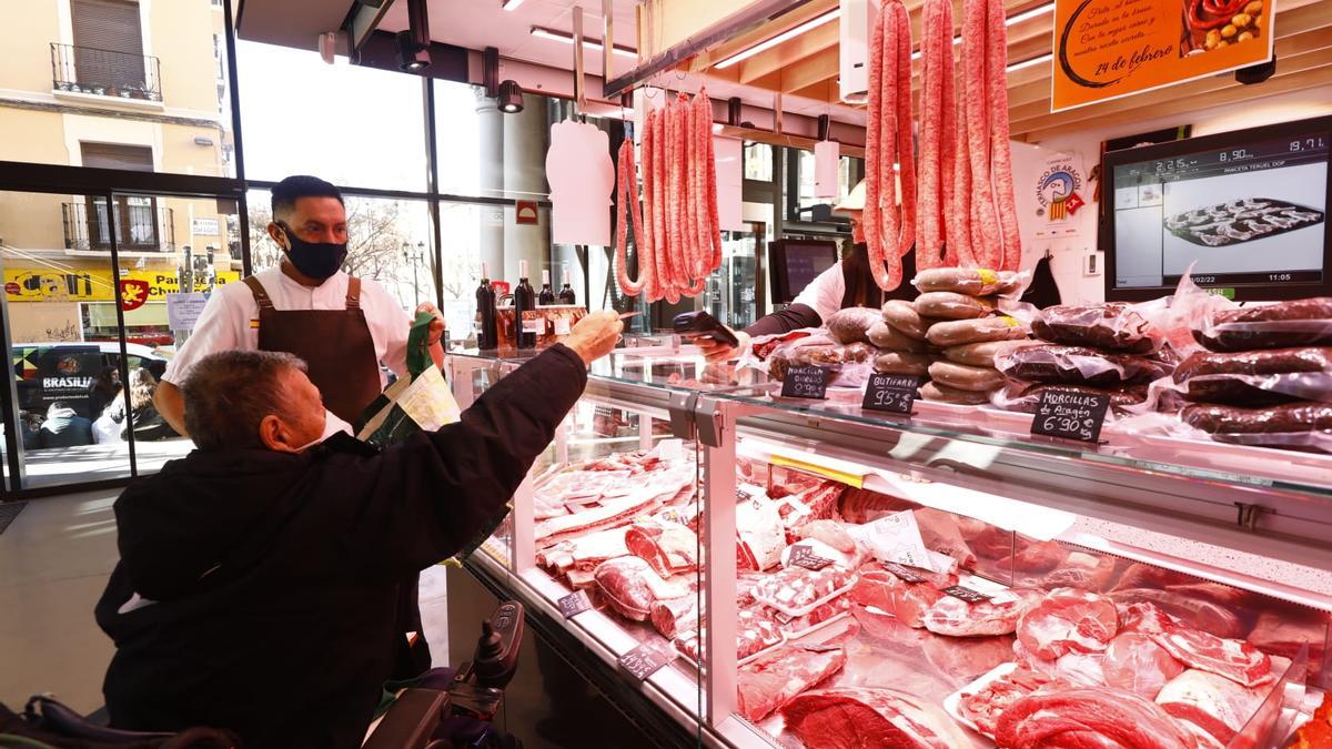 Una clienta compra este jueves en la carnicería Maestros del Corte, en el Mercado Central de Zaragoza.