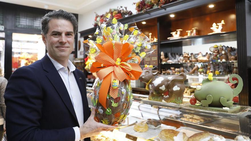 Francisco Gayoso, con un gran huevo de chocolate y junto a varias figuras del mismo producto, en su tienda de la calle San Francisco.