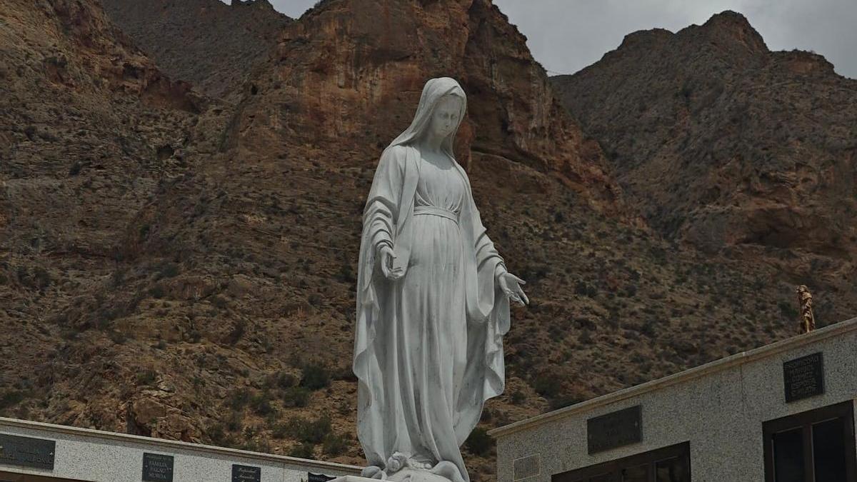Una Virgen corona en el cementerio la peana de la Cruz de Callosa de Segura con los nombres de los caídos del bando nacional en la Guerra Civil