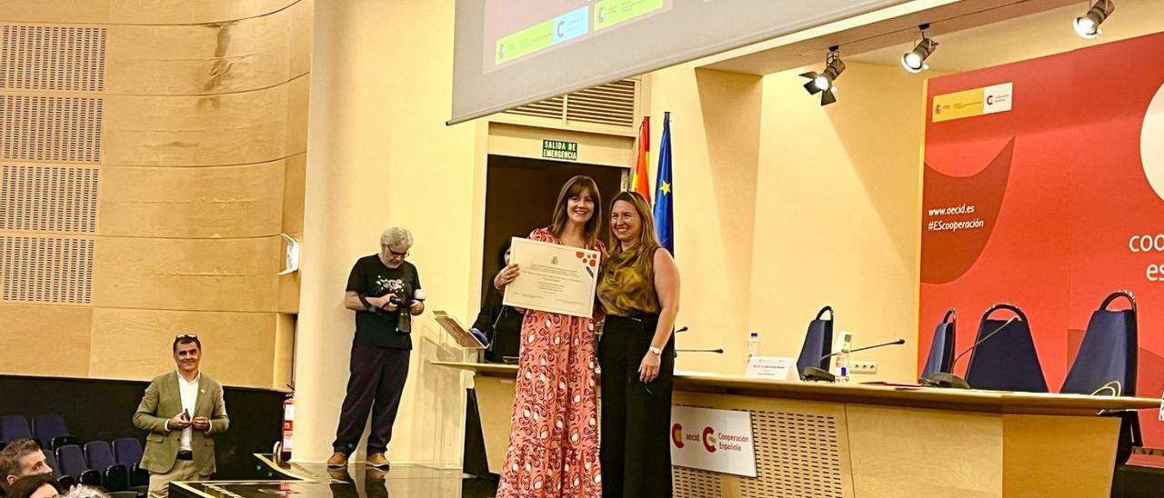 La profesora María Jesús Sánchez (con el diploma en la  mano) recoge el premio con una compañera. | Cedida