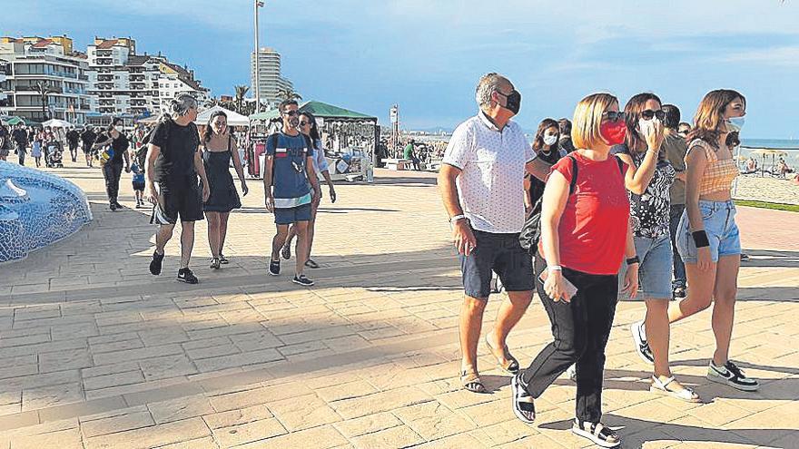 Varios grupos de veraneantes pasean por el litoral de Peñíscola, ayer.