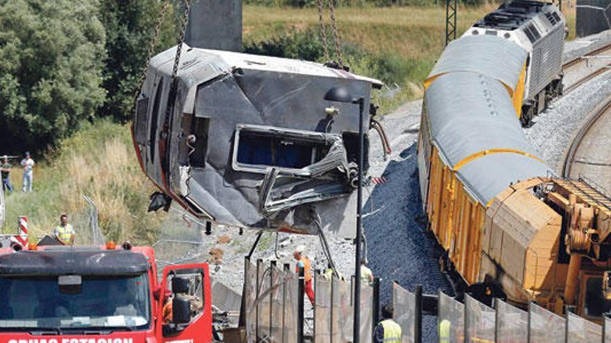 Una grúa se dispone a retirar parte de los restos del convoy que el miércoles descarriló.