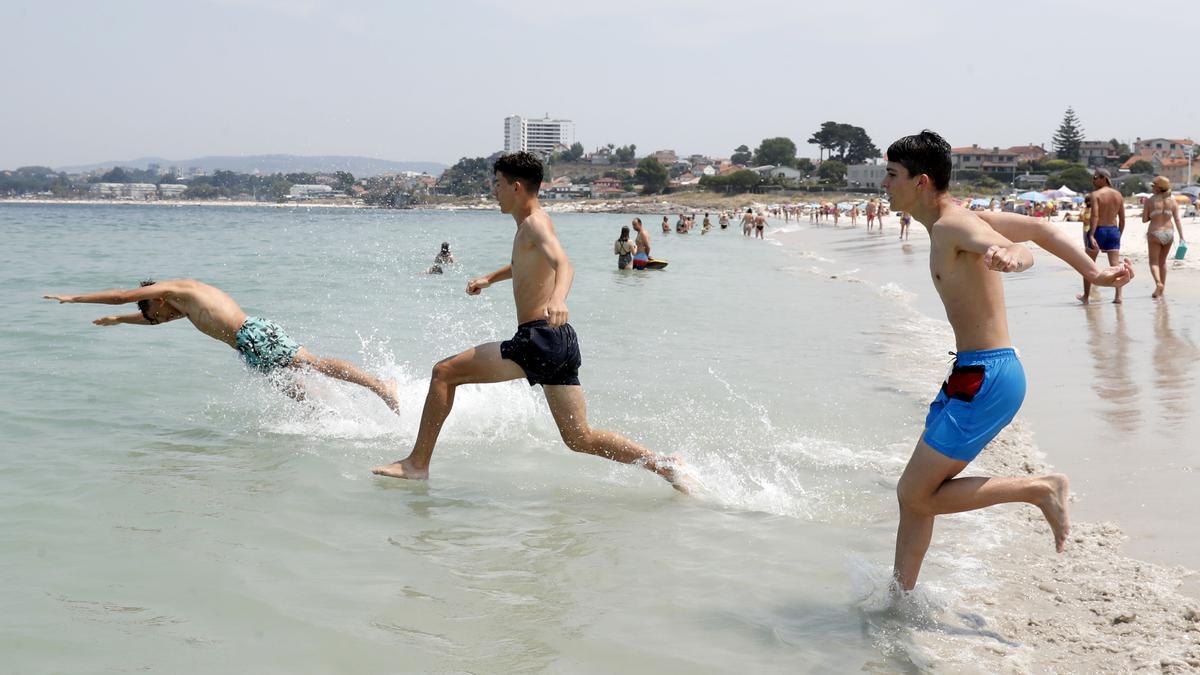 Jóvenes se bañan en la playa de O Vao