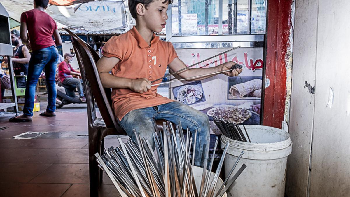 Mrad, de 9 años, trabaja en una parada de kebabs en un mercado en Beirut