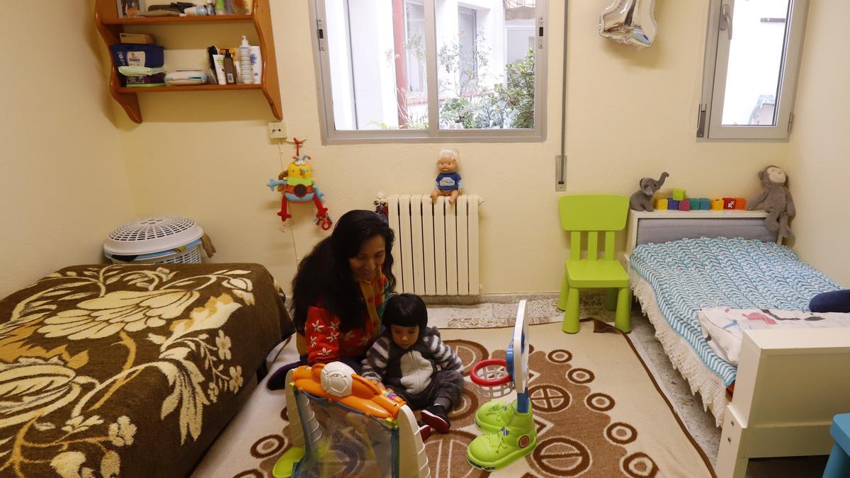 Bettsy juega con su hijo en la habitación de la casa de acogida en la que vive.