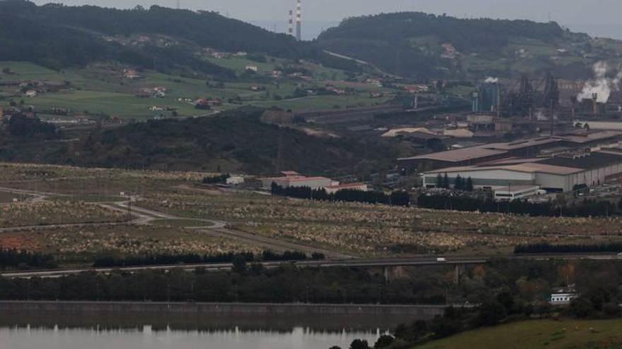 Terrenos de la primera fase de la Zalia, con la factoría de Arcelor-Mittal en Gijón a la derecha.