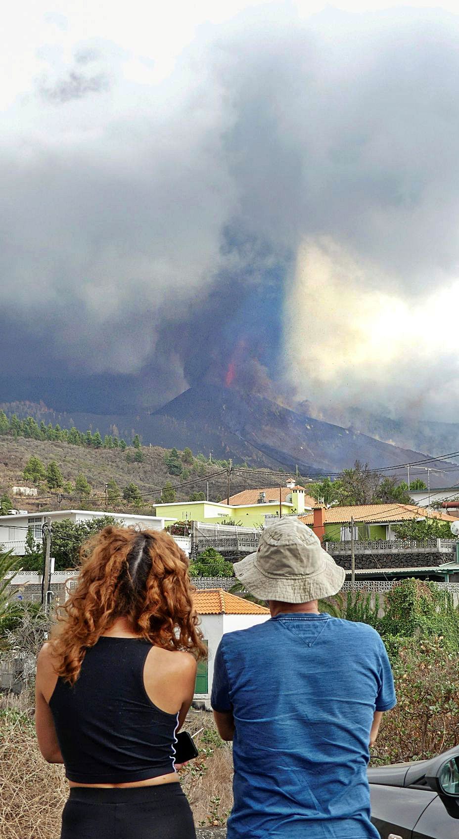 Dos vecinos de La Palma observan la erupción. | Efe