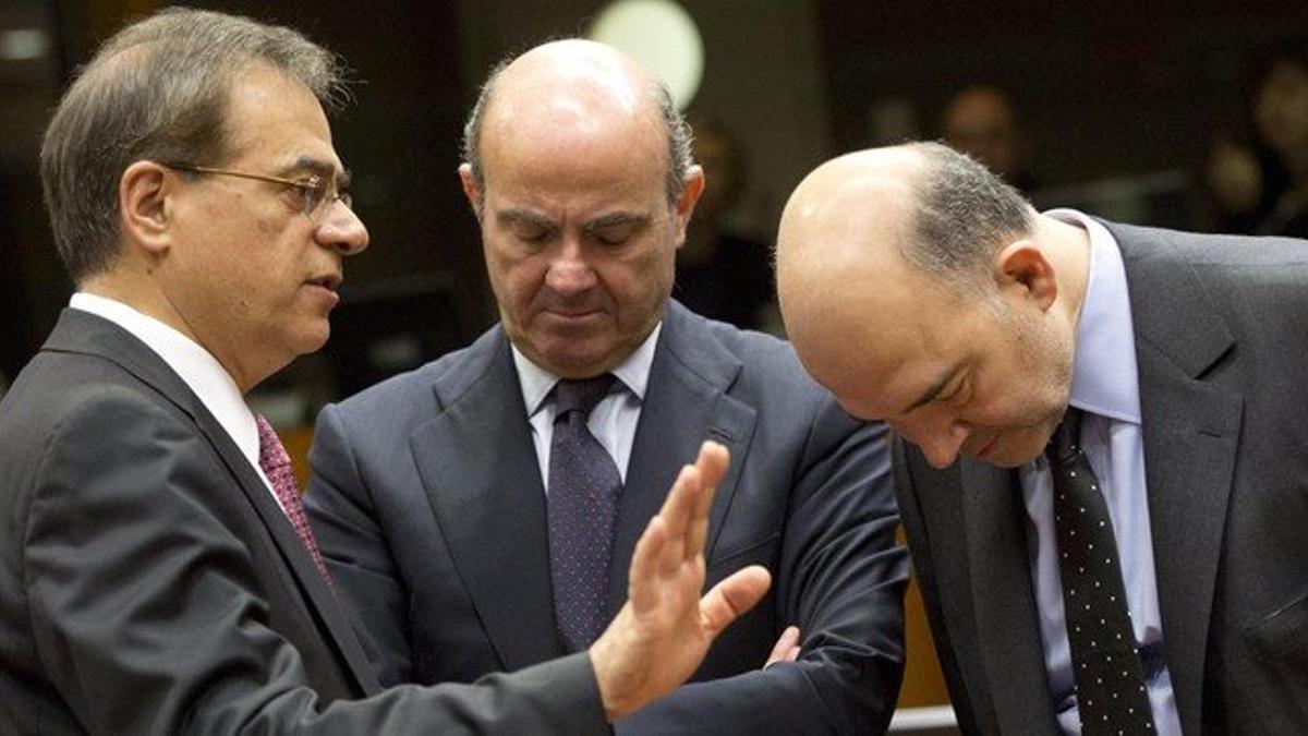 Guindos (centro) conversa con el ministro Griego de Finanzas, Gikas Hardouvelis (izquierda), y el Comisario europeo de Asuntos Económicos y Monetarios, Pierre Moscovici, antes del comienzo de la reunión de ministros de Finanzas de la Unión Europea en
