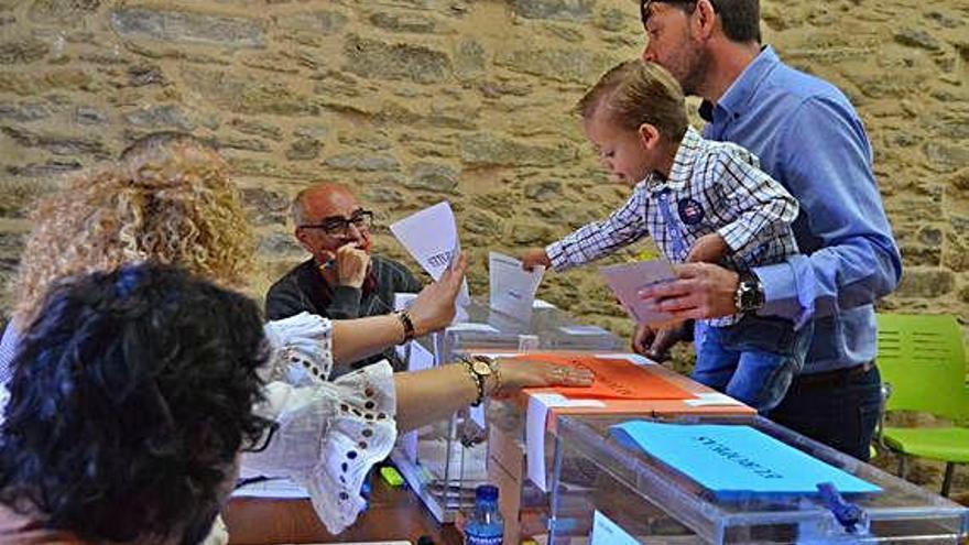 Un niño ayuda a depositar el voto del padre en una urna de Puebla de Sanabria.