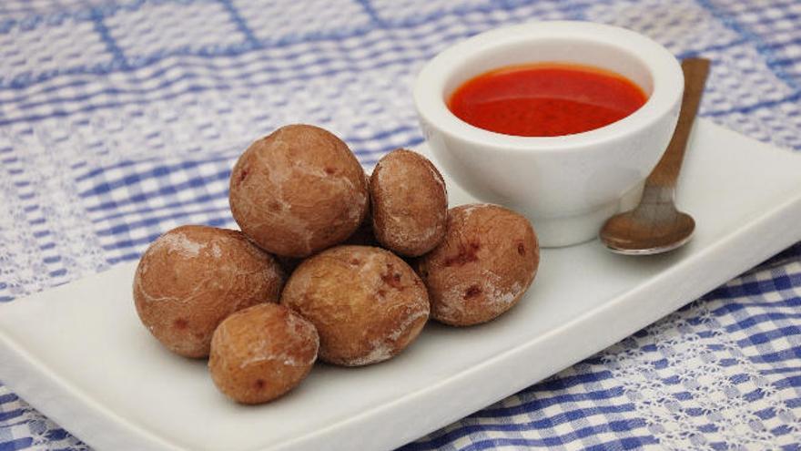 Un plato de papas arrugadas con mojo rojo.