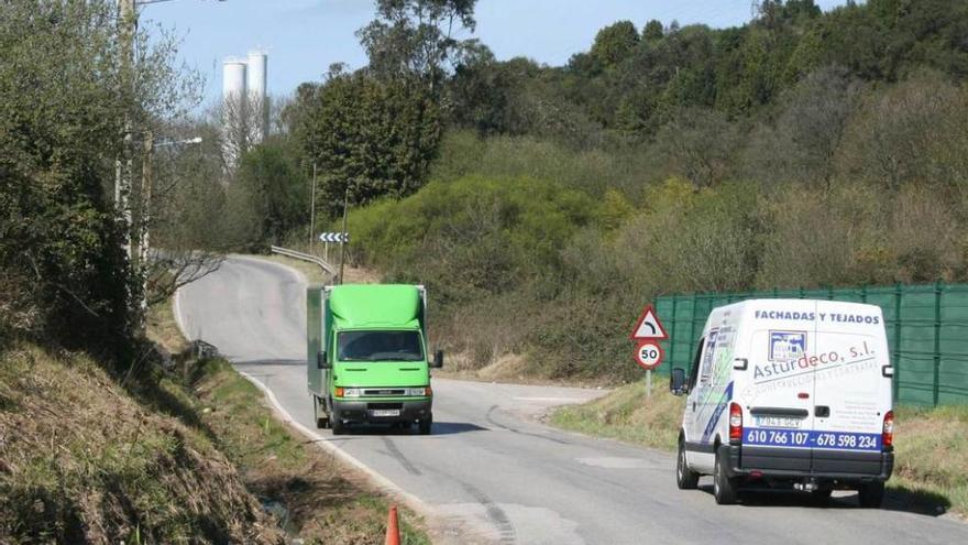 Dos vehículos circulan por la carretera entre Tabaza y Tremañes.