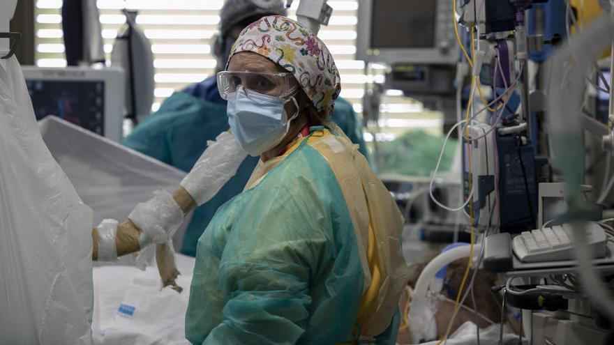 Dos sanitarios atienden a un paciente en la Unidad de Cuidados Intensivos (UCI) dedicada a enfermos de coronavirus.