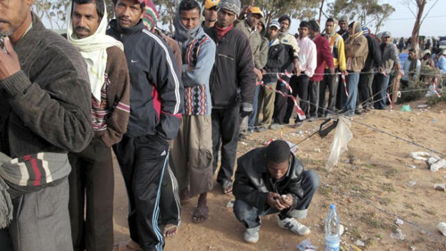 Refugiats fugits de Líbia fan cua per rebre aliments a Tunísia.