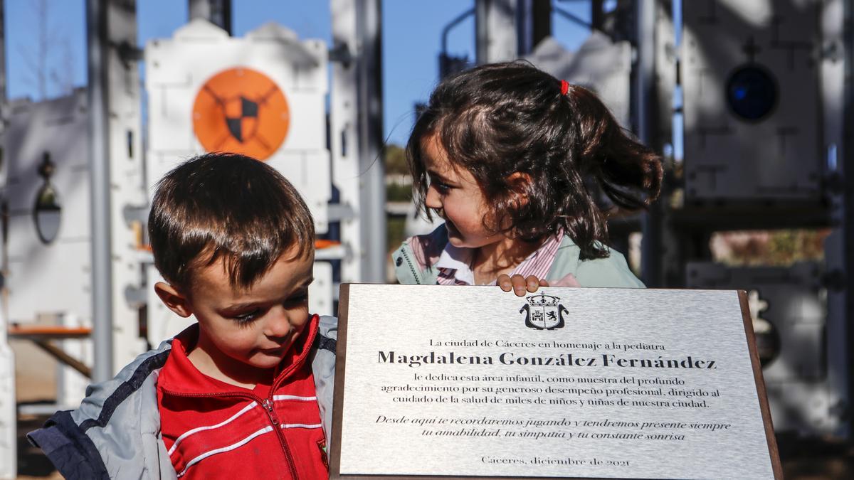 Dos de los pequeños junto a la placa que recuerda a su abuela.