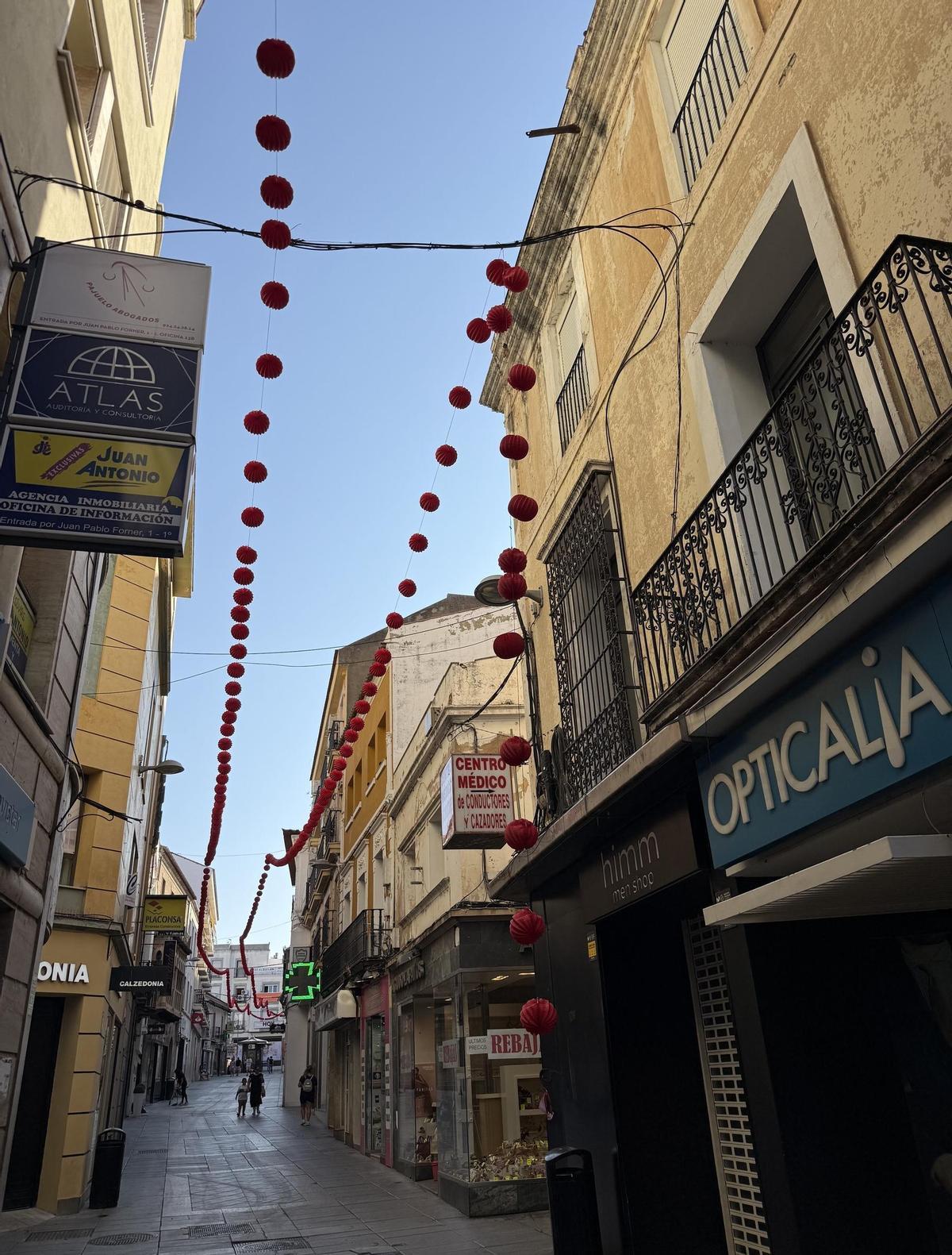 Restos de varios farolillos aparecen esparcidos por el pavimento tras la lluvia y las rachas de viento del miércoles.