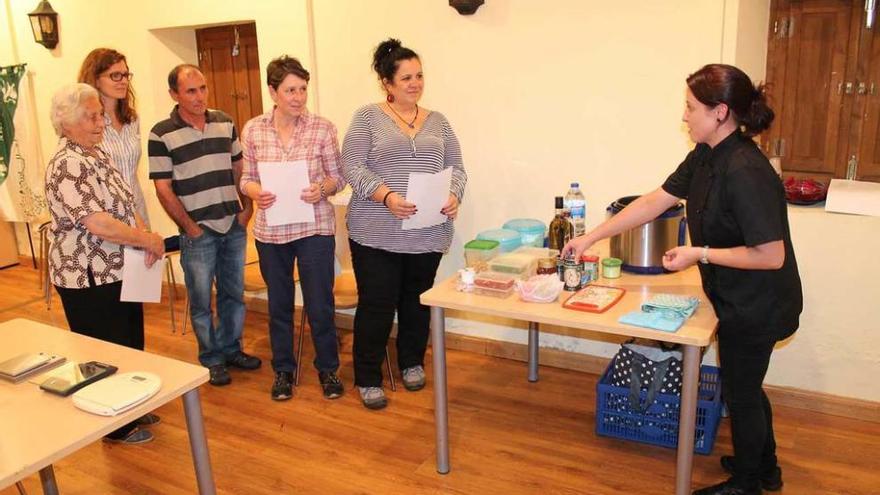 Ángela García, a la derecha, enseñando una receta a los asistentes al taller celebrado en Ables.