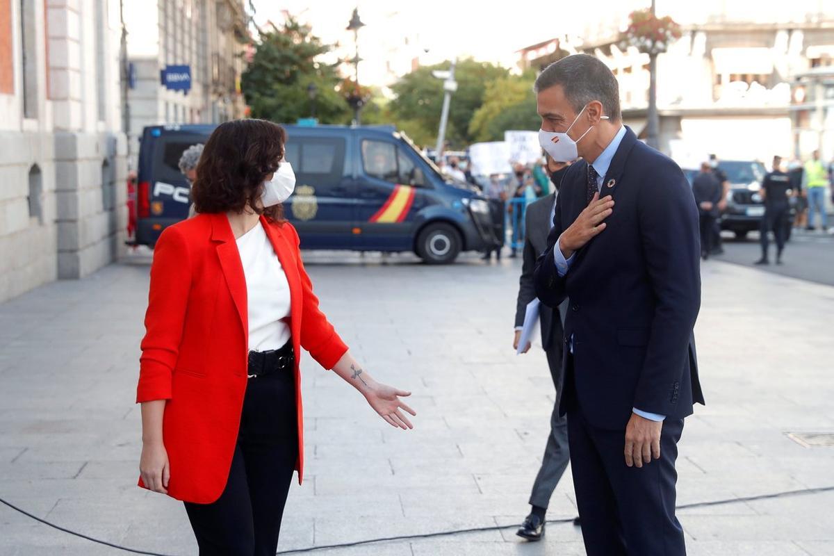 -FOTODELDIA- MADRID, 21/09/2020.- La presidenta de la Comunidad de Madrid, Isabel Díaz Ayuso, recibe este lunes al presidente del Gobierno, Pedro Sánchez, a las puertas de la sede del Gobierno regional, en Madrid, donde ambos han mantenido hoy una reunión para reforzar la colaboración entre ambas administraciones para doblegar la curva en uno de los territorios más castigados por la pandemia de covid-19. El encuentro se celebra el mismo día en el que entran en vigor nuevas medidas de restricción de actividad y de movilidad en 37 zonas básicas de salud de la Comunidad con una mayor incidencia acumulada de coronavirus. EFE/Emilio Naranjo