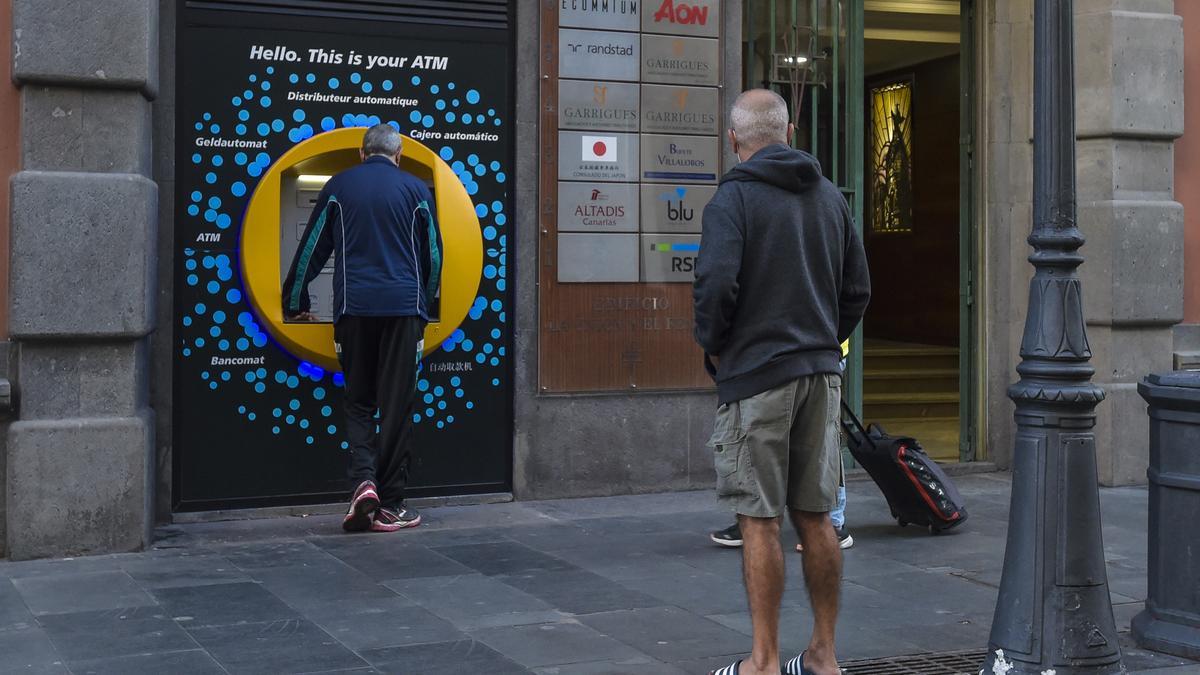 Varias personas esperan para utilizar un cajero.