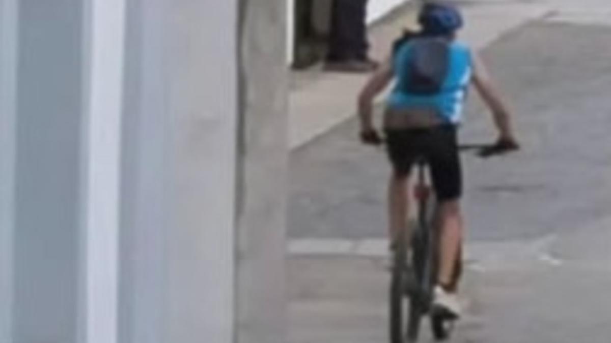 El ciclista, con un maillot azul, huye del lugar del accidente