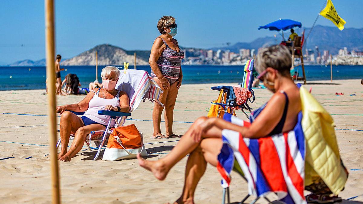 Tres usuarias toman el solen la playa de Levante de Benidorm sin quitarse lasmascarillas, ayer. 