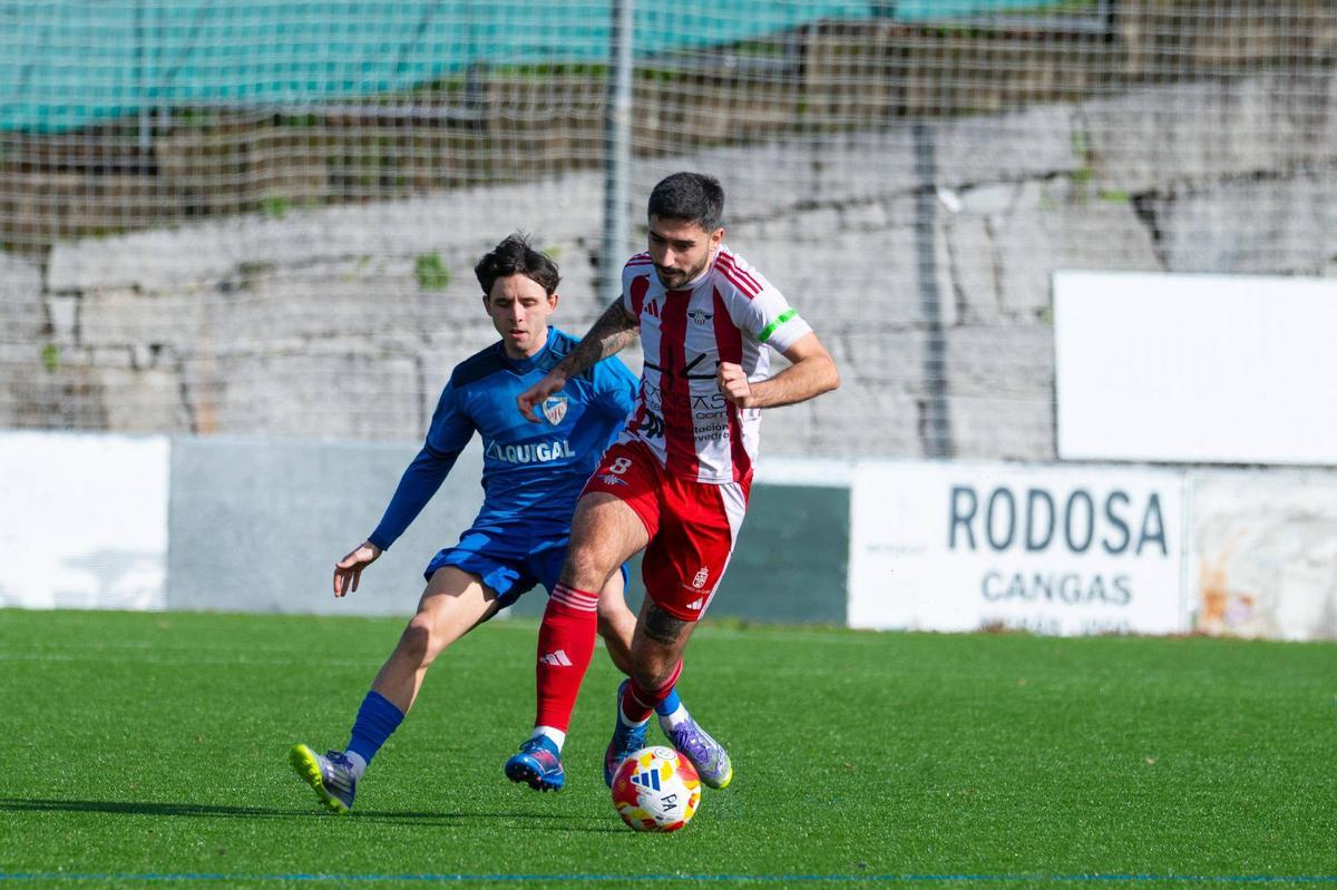 Kopa maneja el balón perseguido por un rival.