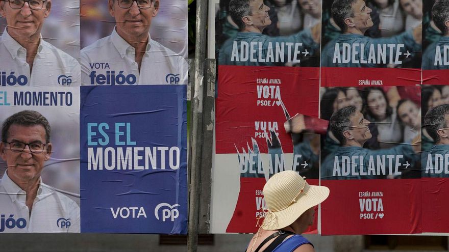 Una mujer pasa ante cartelería de las dos princpales fuerzas políticas en el inicio de la campaña.