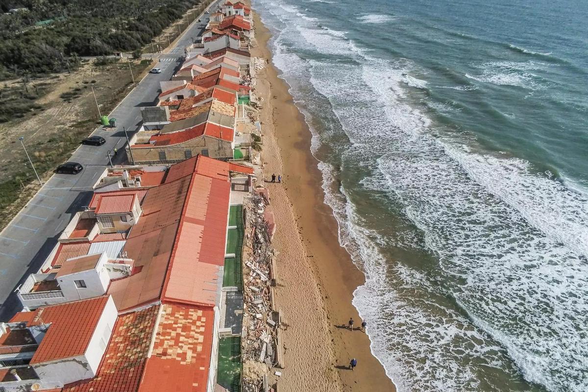 Hilera de viviendas de planta baja sobre la playa de Babilonia y junto al cordón dunar en Guardamar.