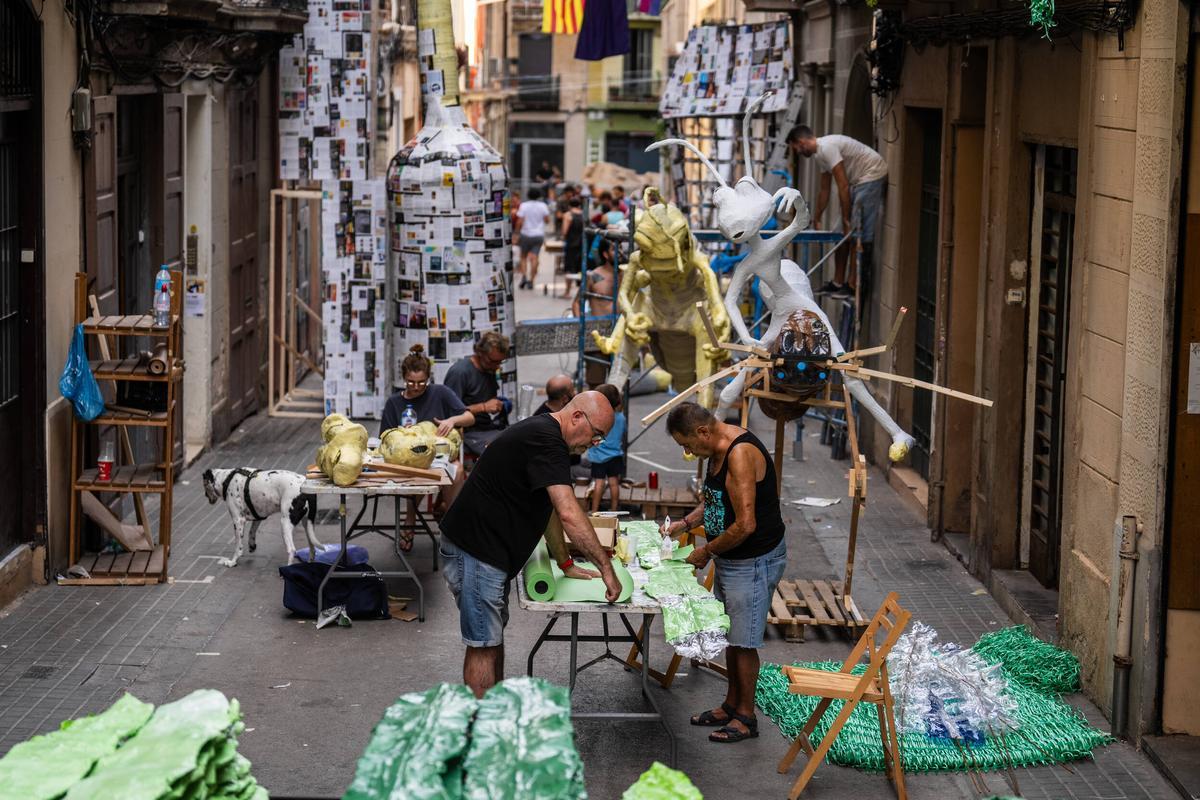 Vecinos en plena faena para ultimar la decoración de la calle Progrés, cuatro días antes de las fiestas de Gràcia 2023