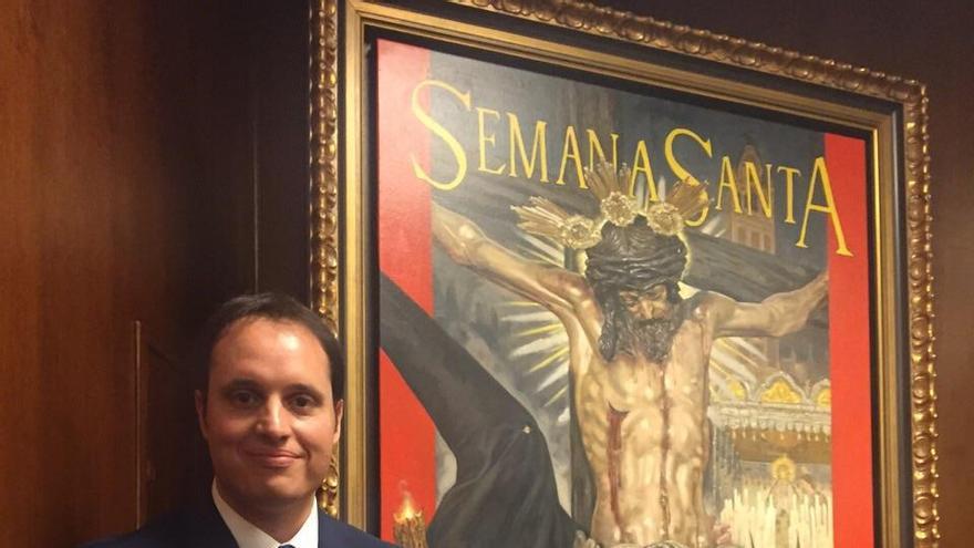 Raúl Berzosa, junto a su cartel de la Semana Santa de Sevilla.