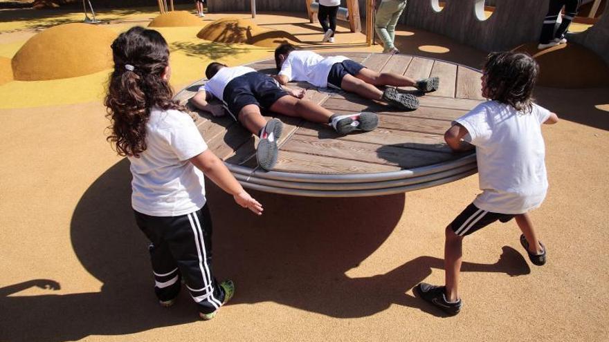 Unos niños juegan en el parque infantil El Laurel.