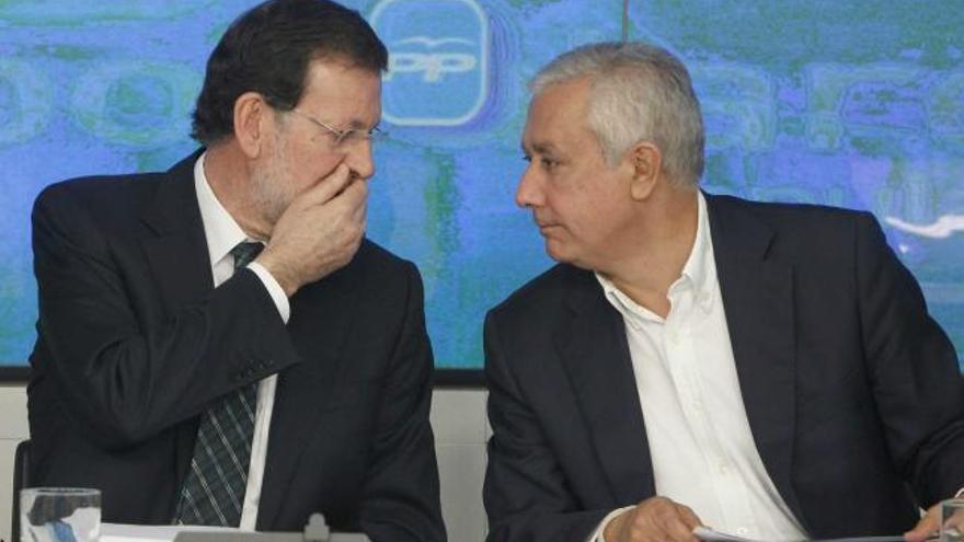 Mariano Rajoy habla con la mano delante de la boca con Javier Arenas en la reunión de ayer en Génova.