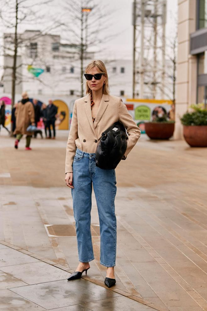 Look con pantalones vaqueros, blazer y mules visto en el 'street style' de Londres