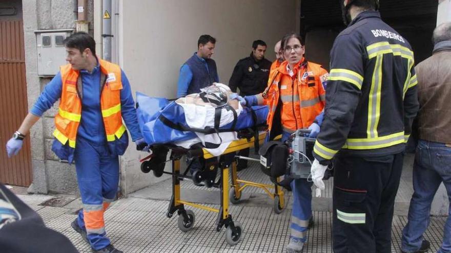 El trabajador es trasladado en camilla a una ambulancia. // Santos Álvarez