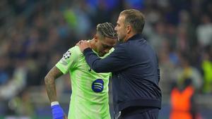 Flick intenta consolar a Raphinha tras la eliminación europea del Barça ante el Inter en San Siro.