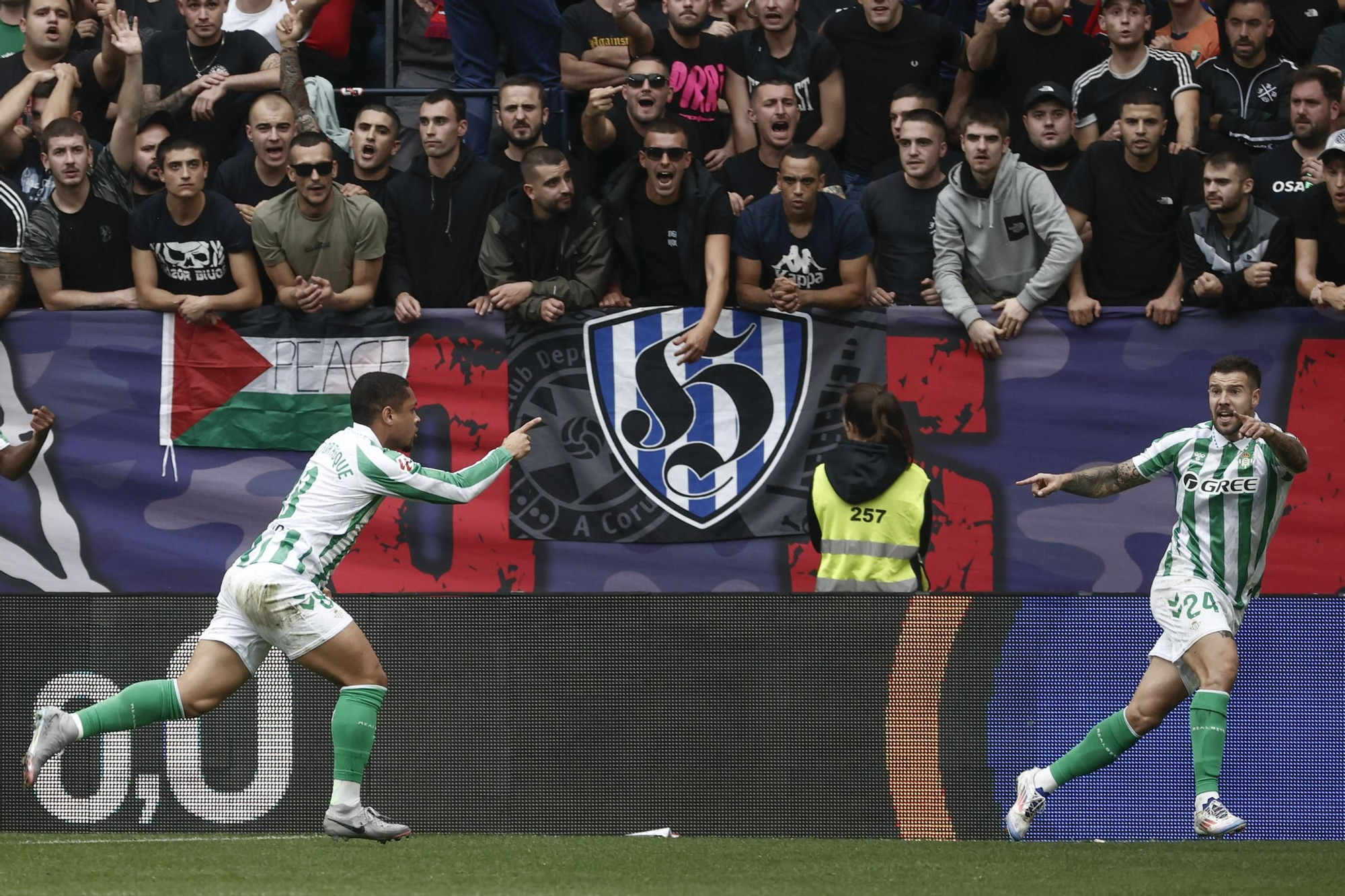 PAMPLONA, 19/10/2024.- El delantero brasileño del Betis Vitor Roque (i) celebra junto a sus compañeros tras anotar el 0-1 durante el encuentro correspondiente a la décima jornada de LaLiga entre el Osasuna y el Betis en El Sadar, Pamplona, Navarra, este sábado. EFE/ Jesús Diges
