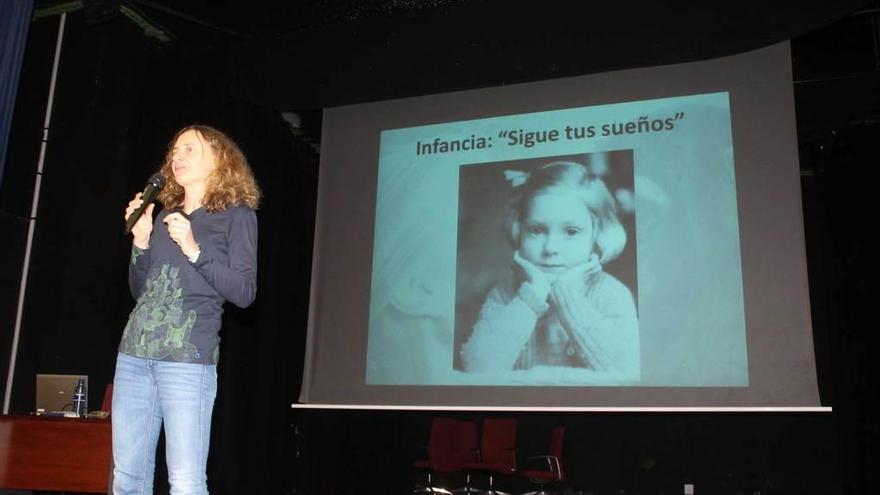 La profesora Marta González, durante su charla en el Instituto de Luarca, con una imagen de Jane Goodall cuando era una niña a su espalda.