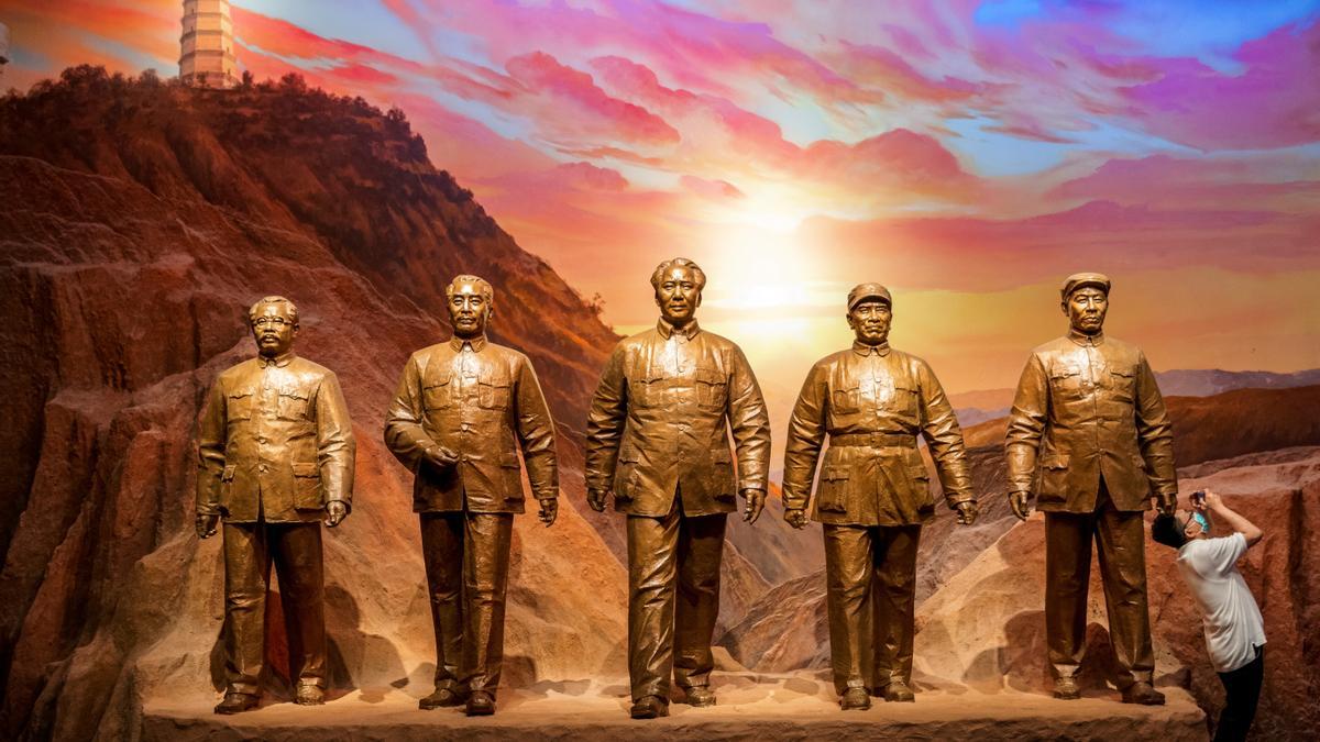 Un hombre toma fotografías junto a las estatuas de los exlíderes comunistas chinos en el Museo del Partido Comunista de China.