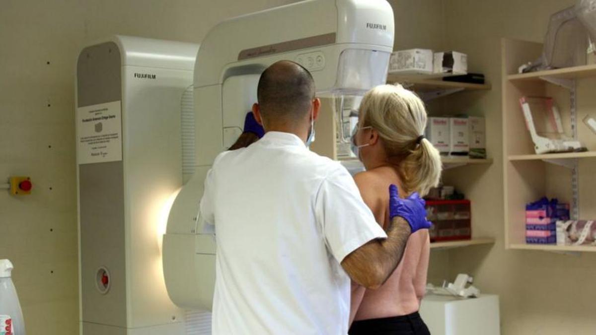 Una dona passant una mamografia.