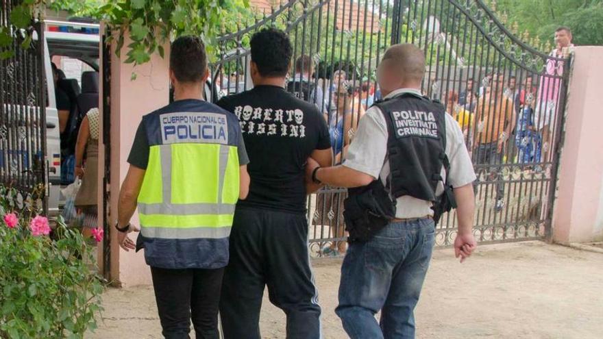 Miembros de la Policía española y rumana llevan a un detenido. efe