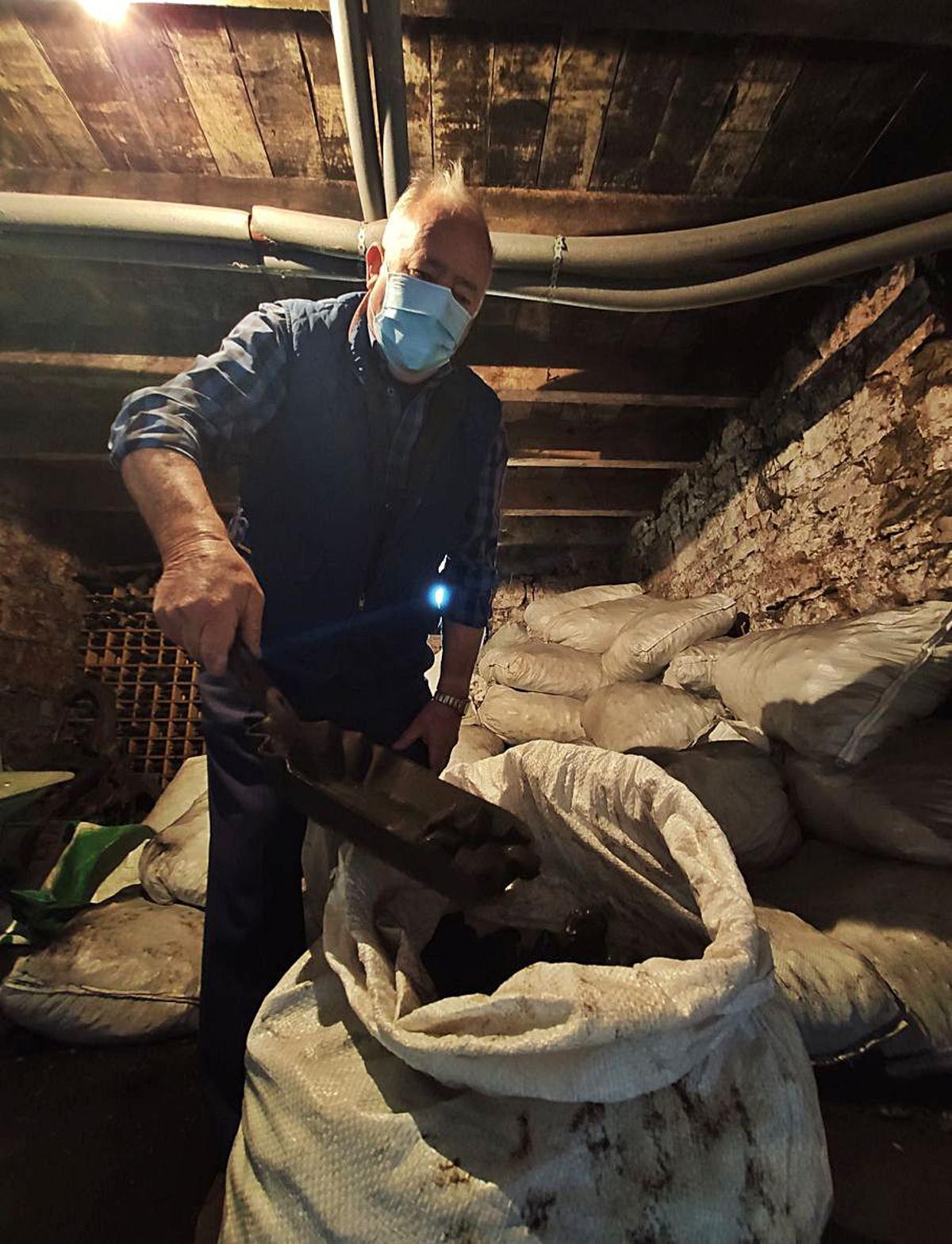 Morán carga una pala de carbón en su carbonera de Campo.