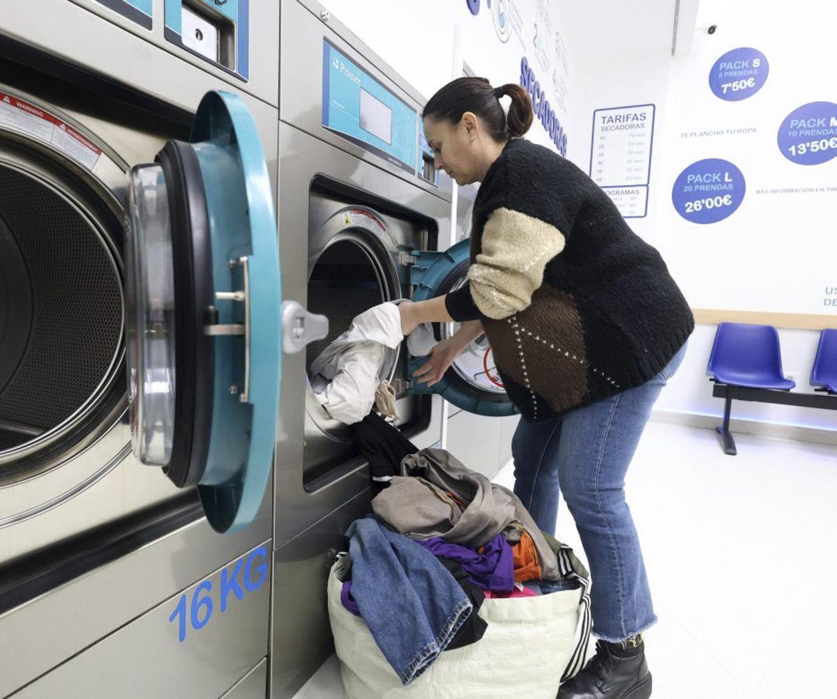 Irene Limeres vaciando una secadora en la Lavandería A Barca. | GUSTAVO SANTOS