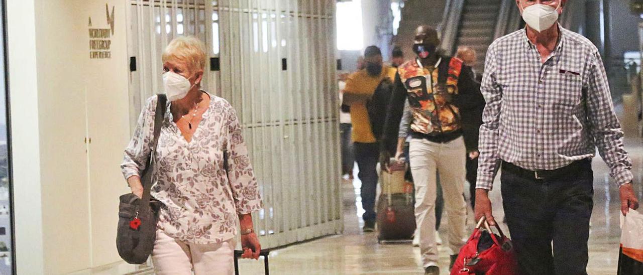 Turistas británicos llegando ayer al aeropuerto. Abajo, pubs británicos en Benidorm. | PILAR CORTÉS/ R.PAGÉS