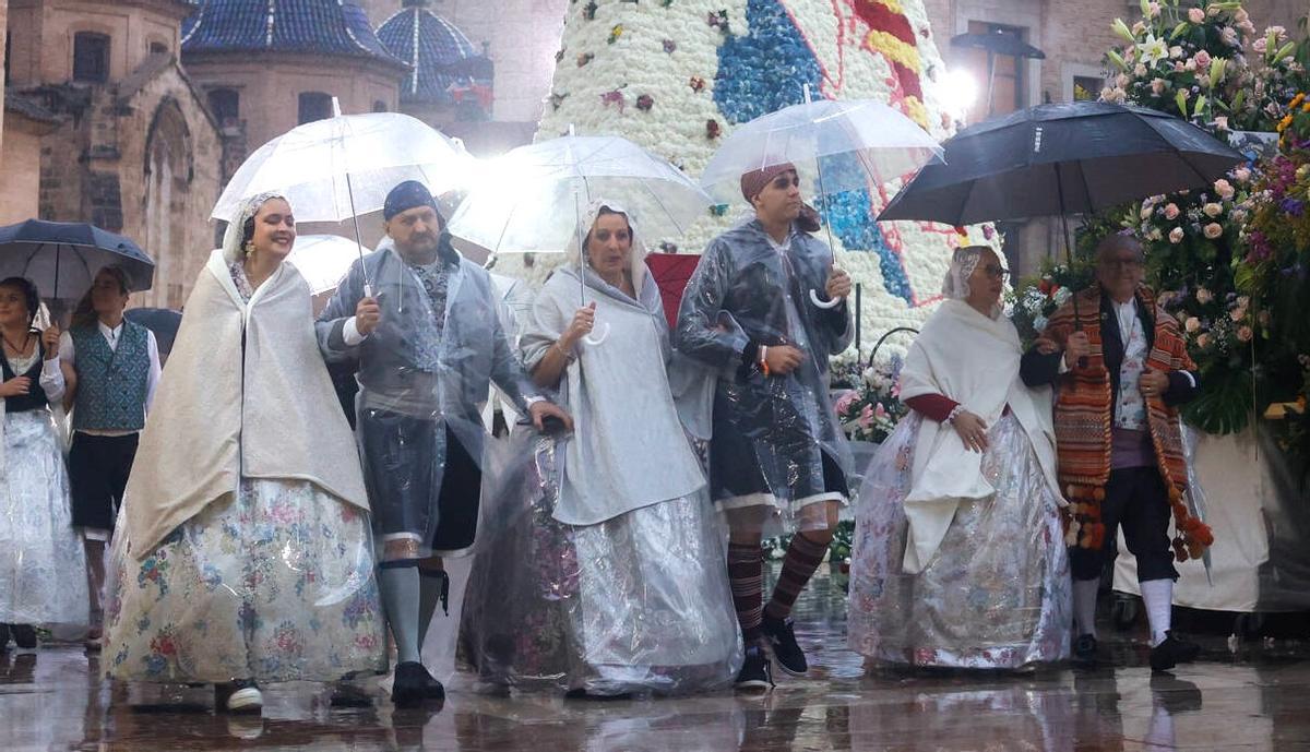 Falleros a cubierto en la pasada Ofrenda